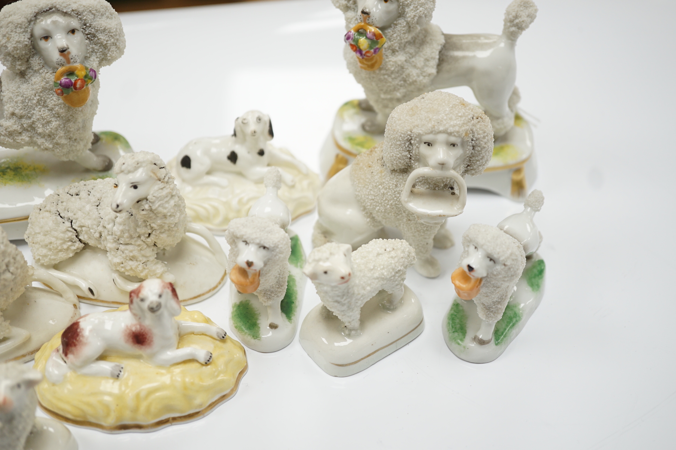 Two Samuel Alcock models of recumbent spaniels, a Staffordshire porcelain model of a seated spaniel and six similar sheep c.1830-50, and five Continental porcelain models of poodles (11)